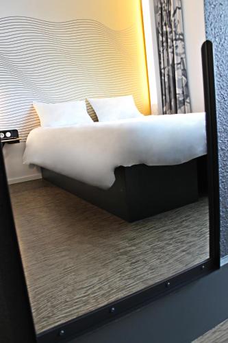a reflection of a bed in a mirror at B&B HOTEL Lille Centre Grand Palais in Lille