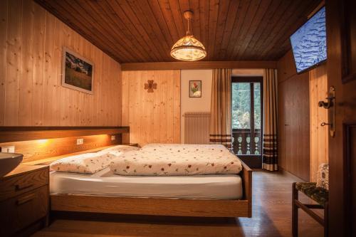 1 dormitorio con 1 cama en una habitación de madera en Casa Serac´, en La Valle