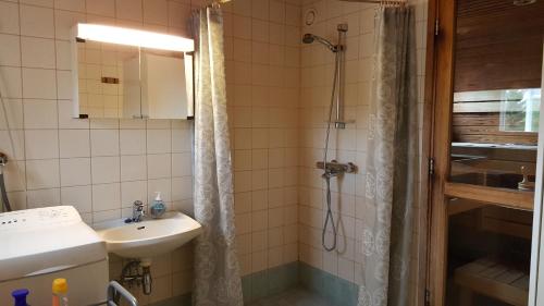 a bathroom with a sink and a shower at Hulda`s Apartment by the river in Heinola