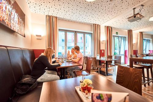 a group of people sitting at tables in a restaurant at DJH-Gästehaus Bermuda3Eck in Bochum