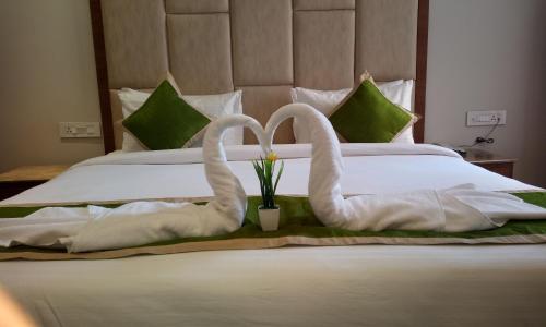 two swansrendered to look like they are kissing on a bed at Maple Grand in Agra