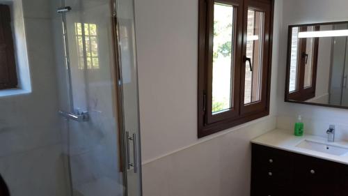 un bagno con doccia, lavandino e specchio di Apartamento de Lujo Av. Barber a Toledo