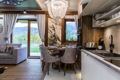 eine Küche mit einem Tisch, Stühlen und einem Sofa in der Unterkunft Aspen Ski Szymaszkowa in Zakopane