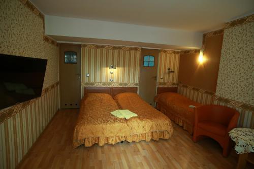 1 dormitorio con 1 cama, 1 silla y TV en AbWentur Pokoje, en Gdansk