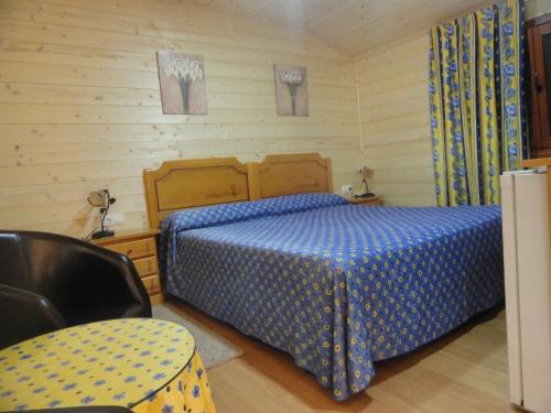 ein Schlafzimmer mit einem Bett, einem Tisch und einem Stuhl in der Unterkunft Hostal Gran Avenida in Tarancón