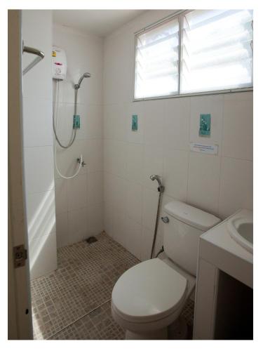 a bathroom with a toilet and a shower and a sink at Namhasin House in Koh Tao