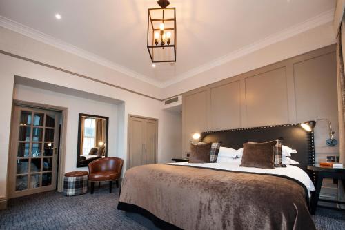 a hotel room with a bed and a chair at Macdonald Burlington Hotel in Birmingham