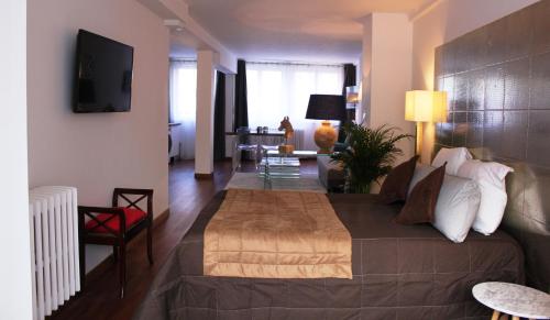a bedroom with a large bed and a living room at Résidence et Chambres d'Hôtes de La Porte d'Arras in Douai