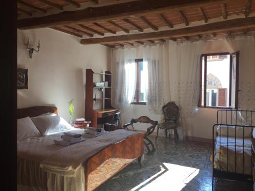 a bedroom with a bed and a desk and windows at La Casa di Luigi in Montevarchi