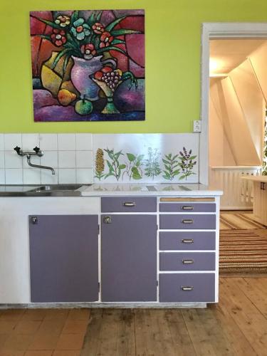 a kitchen with a sink and a painting on the wall at Parkgatan villa in Krylbo