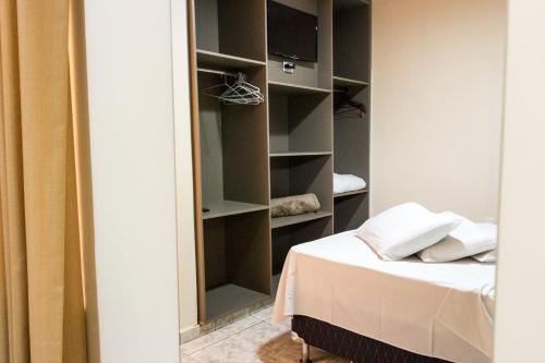 a bedroom with a bed and a closet at Colonial Hotel Itatiba in Itatiba