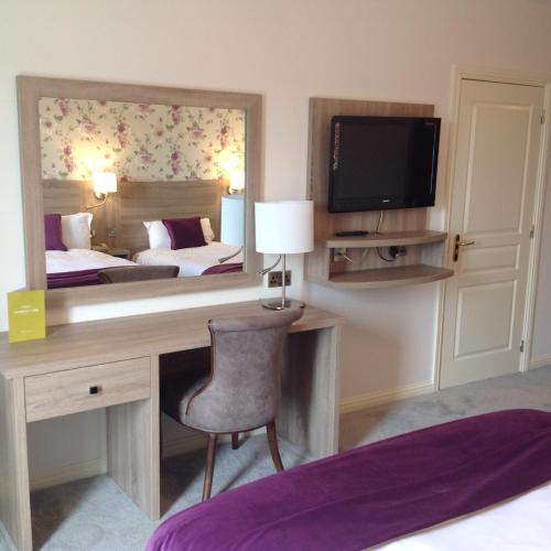 a bedroom with a desk and a bed and a mirror at The Landmark Hotel in Carrick on Shannon