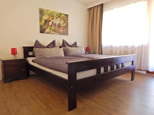 a large bed in a bedroom with a large window at FREE Apartment - Bei den Thermen in Bad Urach