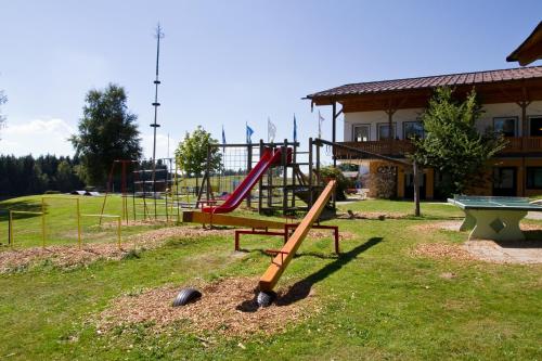 a playground with a red slide in a yard at Knaus Campingpark Lackenhäuser in Neureichenau