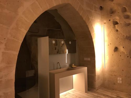 a bathroom with a sink in a stone wall at B&B Al Convento in Matera