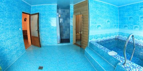 a blue bathroom with a tub and a sink at Greku Hotel in Bukovel