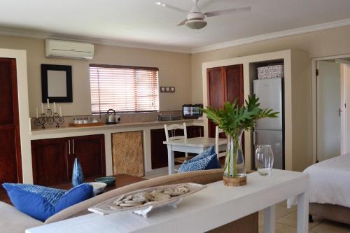 a kitchen and living room with a couch and a table at Claire's Deluxe Studio Apartment - SOLAR in Ballito