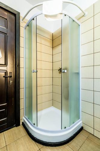 a shower with a glass door in a bathroom at Pensiunea La Moară in Fundu Moldovei
