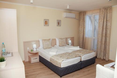 Un dormitorio con una cama grande y una ventana. en Luxury Apartments, en Burgas