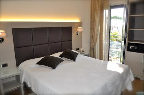 a bedroom with a large white bed with two pillows at Hotel Etruria in Forte dei Marmi