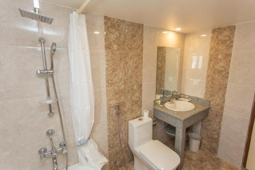 a bathroom with a toilet and a sink and a shower at Hotel White Pearl in Pokhara