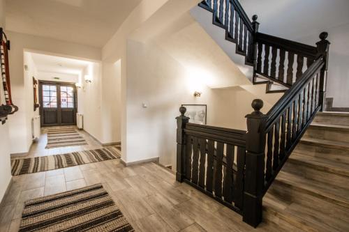 a staircase in a home with a black railing at Pensiunea La Moară in Fundu Moldovei