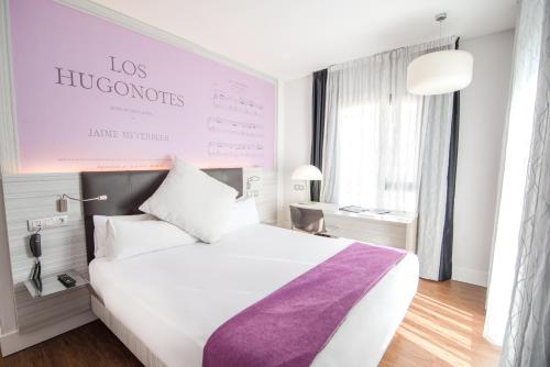 una camera d'albergo con un letto bianco e una coperta viola di Petit Palace Boqueria Garden a Barcellona