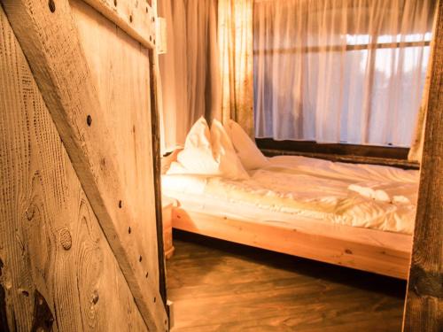 a bed in a wooden room with a window at Agroturystyka u Karoliny in Sarbinowo