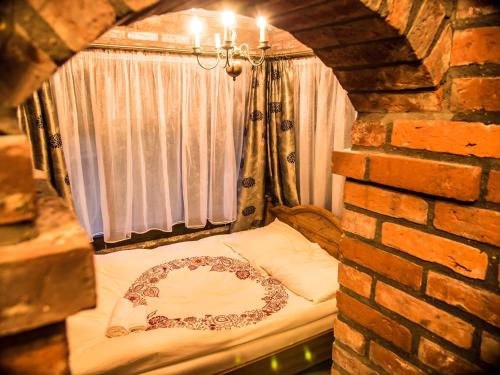 a bed in a room with a brick wall at Agroturystyka u Karoliny in Sarbinowo