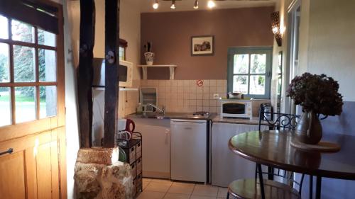una cocina con una mesa y una encimera en Gites de la Ferme de l'Eglise, en Fatouville-Grestain