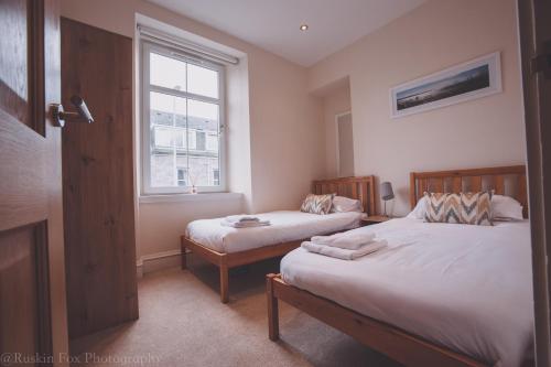 a bedroom with two beds and a window at Apartment C in Aberdeen