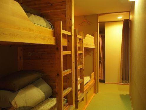 a room with two bunk beds and a hallway at Aso Base Backpackers in Aso