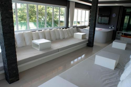 una sala de estar con muebles blancos y ventanas grandes. en Marina Residence, en Bangrak Beach