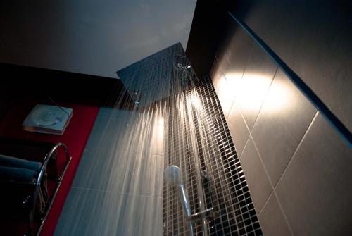 a shower in a bathroom with a light on the wall at Marina Residence in Bang Rak Beach