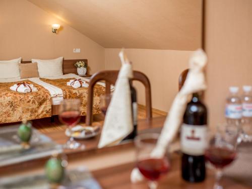 a room with a bed and a table with glasses of wine at Hotel&SPA Pysanka, Готель Писанка, 3 сауни та джакузі - індивідуальний відпочинок у СПА in Lviv