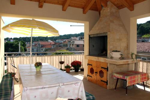 een patio met een tafel en een buitenoven bij Villa Gabre in Tisno