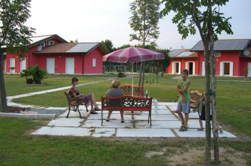 a group of people sitting on benches in a park at Dogana Vecchia - Hotel & Residence B&B Ristorante & Pizzeria in Trivignano Udinese