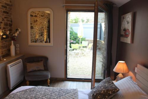 a bedroom with a bed and a sliding glass door at Gîte de Kermal in Bannalec