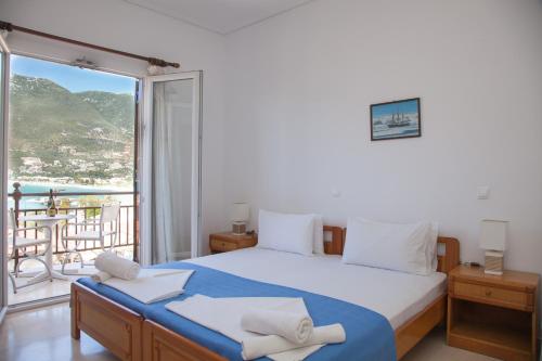 a bedroom with a large bed and a balcony at Captain's Studios in Vasiliki