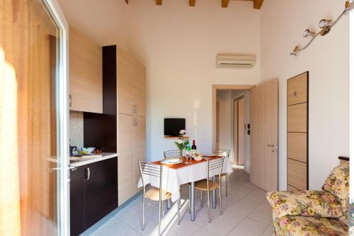 a kitchen and a dining room with a table and chairs at Dogana Vecchia - Hotel & Residence B&B Ristorante & Pizzeria in Trivignano Udinese