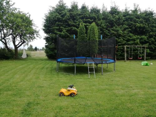 a small toy car in the grass next to a trampoline at Agroturystyka u Karoliny in Sarbinowo
