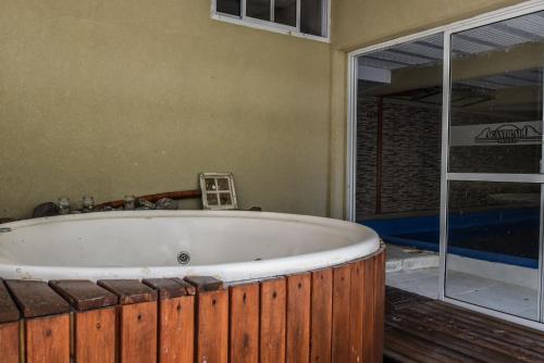 a bath tub in a room with a sliding glass door at Hotel Acantilado in Las Grutas