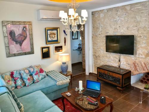 sala de estar con sofá y mesa con ordenador portátil en Apartamento con Terraza,a 100m playa Costilla y Frente al Castillo, en Rota