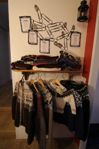 a rack of coats and scarves hanging on a wall at CJA Guesthouse in Laugar