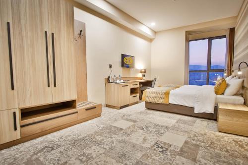 a bedroom with a bed and a desk and a window at Ameri Plaza Tbilisi in Tbilisi City
