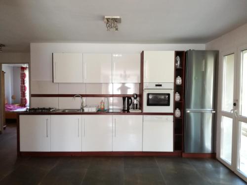 a kitchen with white cabinets and a refrigerator at Agroturystyka u Karoliny in Sarbinowo