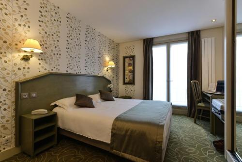 a hotel room with a bed and a desk at Relais du Pré in Paris