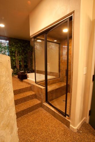 a bathroom with a walk in shower next to some stairs at Destinations Inn Theme Rooms in Idaho Falls