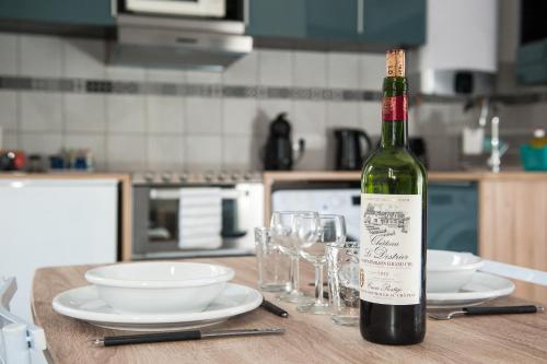 une bouteille de vin posée sur une table avec des verres dans l'établissement #StudioCosy @ Center Cannes, à Cannes