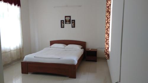 a bedroom with a bed with white sheets at Tulip Serviced Villa in Chennai